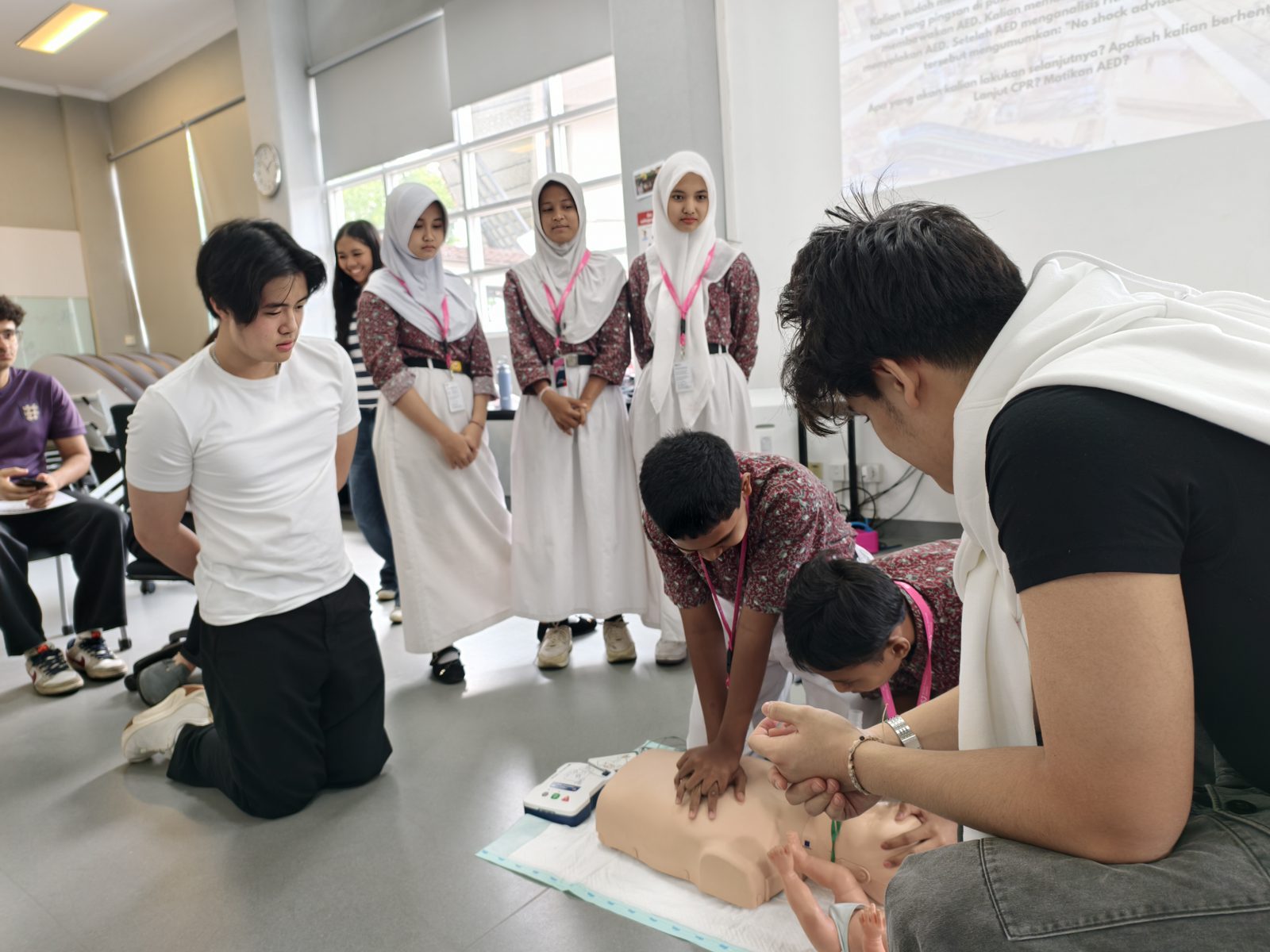Students practicing CPR on a training manikin at a Beatkeepers workshop